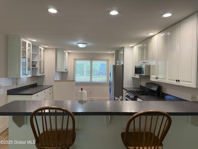 12 Graves St, Glens Falls, NY 12801 - kitchen featuring stainless steel appliances, dark countertops, a peninsula, a breakfast bar area, and recessed lighting