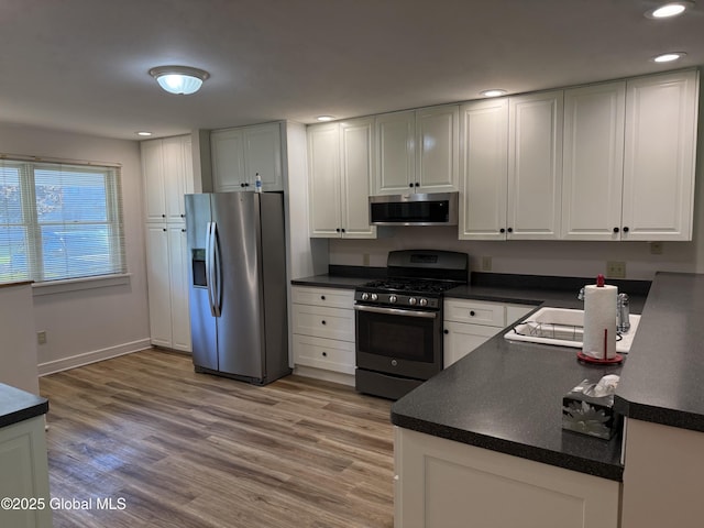 12 Graves St, Glens Falls, NY 12801 - kitchen featuring stainless steel appliances, recessed lighting, dark countertops, and white cabinetry