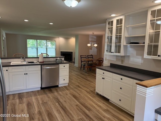 12 Graves St, Glens Falls, NY 12801 - kitchen with stainless steel dishwasher, a sink, a chandelier, wood finished floors, and dark countertops