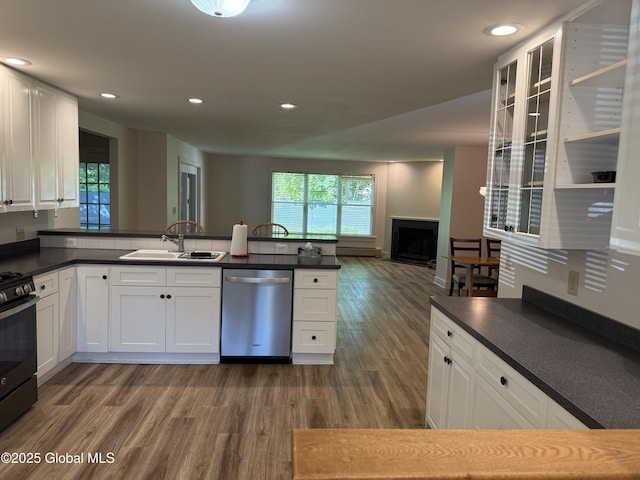12 Graves St, Glens Falls, NY 12801 - kitchen featuring dishwasher, a sink, black gas range, dark wood-type flooring, and a fireplace