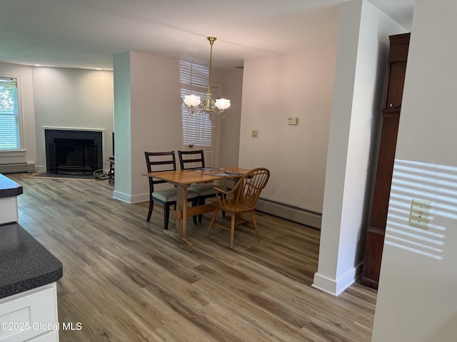 12 Graves St, Glens Falls, NY 12801 - dining room featuring baseboard heating, light wood-style floors, baseboards, and a chandelier