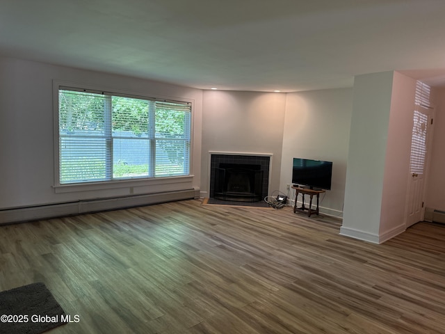 12 Graves St, Glens Falls, NY 12801 - unfurnished living room with a baseboard heating unit, a tile fireplace, wood finished floors, and baseboards