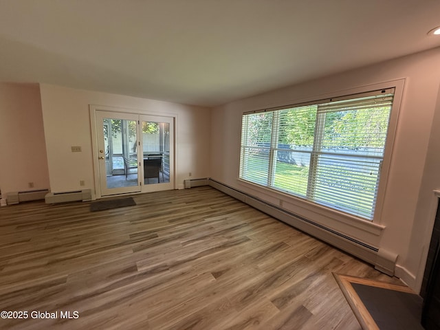 12 Graves St, Glens Falls, NY 12801 - spare room featuring baseboard heating, wood finished floors, and baseboards
