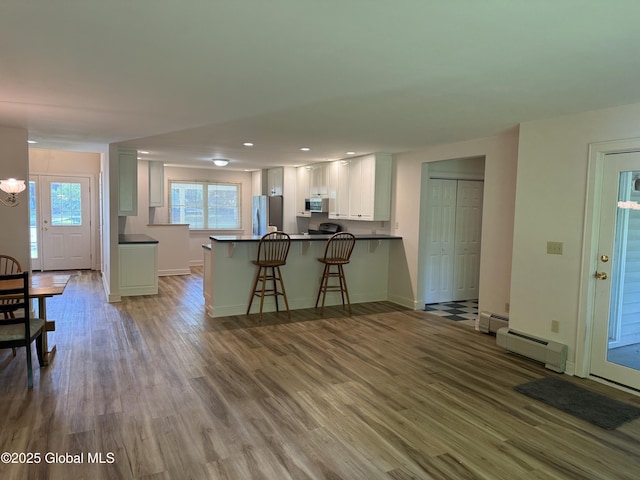12 Graves St, Glens Falls, NY 12801 - kitchen with a baseboard heating unit, dark countertops, a peninsula, stainless steel appliances, and recessed lighting