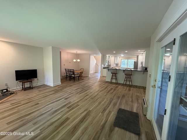 12 Graves St, Glens Falls, NY 12801 - living area featuring light wood finished floors, a chandelier, a baseboard radiator, recessed lighting, and baseboards