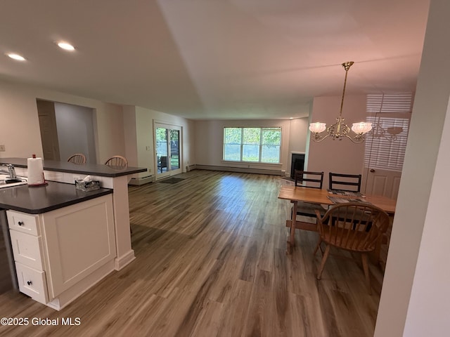 12 Graves St, Glens Falls, NY 12801 - kitchen with dark countertops, white cabinets, dark wood-type flooring, open floor plan, and a chandelier