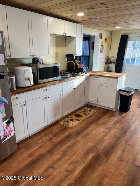 159 Champlain Ave, Ticonderoga, NY 12883 - kitchen featuring wooden ceiling, stainless steel microwave, white cabinetry, and butcher block countertops
