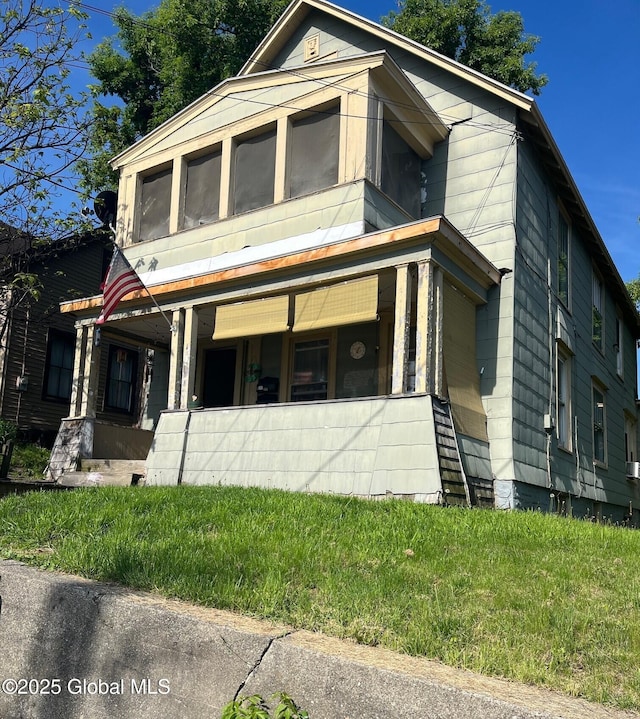 159 Champlain Ave, Ticonderoga, NY 12883 - view of front of home featuring covered porch, a sunroom, and a front yard