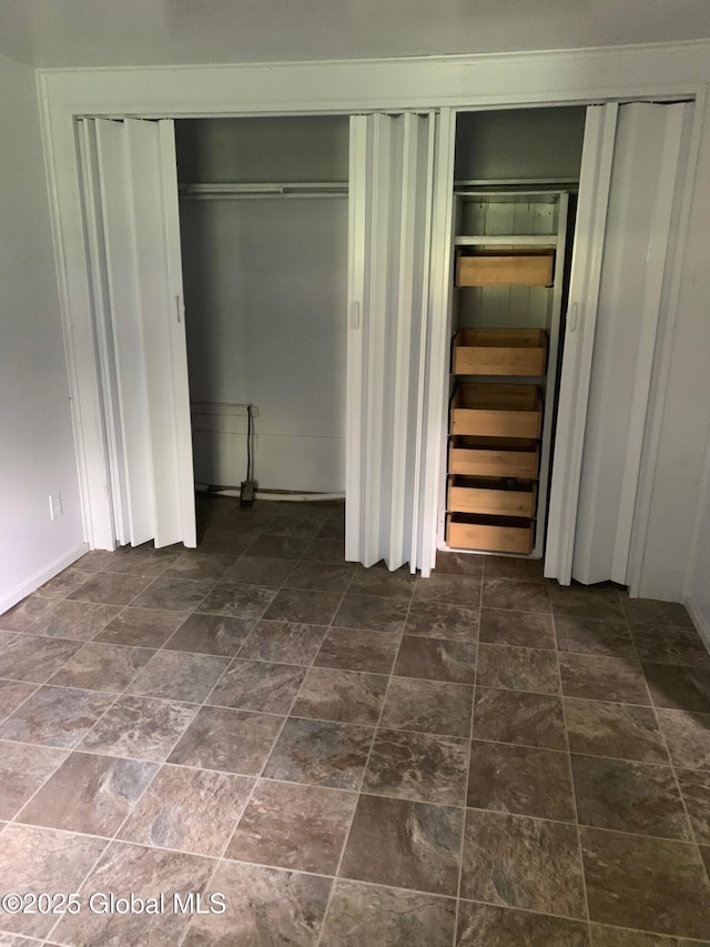 326 Middle Rd, Crown Point, NY 12928 - unfurnished bedroom featuring dark stone finish floors and multiple closets