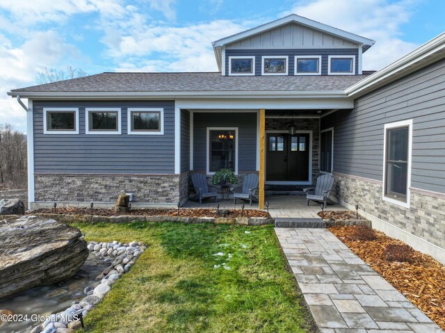 74 Dick Hyatt Ln, Whitehall, NY 12887 - view of exterior entry with a porch, a lawn, roof with shingles, and board and batten siding