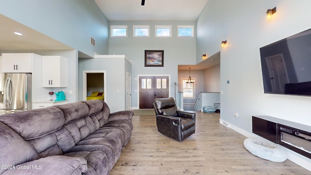 74 Dick Hyatt Ln, Whitehall, NY 12887 - living area featuring a high ceiling, light wood-style flooring, baseboards, and a chandelier