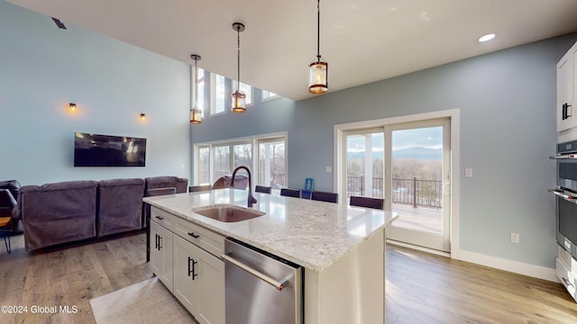 74 Dick Hyatt Ln, Whitehall, NY 12887 - kitchen featuring a sink, stainless steel dishwasher, light wood-type flooring, hanging light fixtures, and white cabinets
