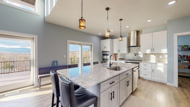 74 Dick Hyatt Ln, Whitehall, NY 12887 - kitchen with a sink, wall chimney range hood, white cabinets, light wood-type flooring, and recessed lighting