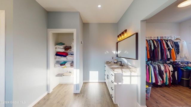74 Dick Hyatt Ln, Whitehall, NY 12887 - bathroom with vanity, wood finished floors, a walk in closet, baseboards, and recessed lighting