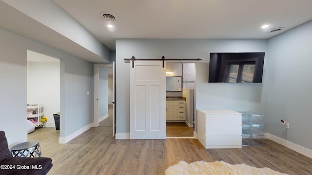 74 Dick Hyatt Ln, Whitehall, NY 12887 - bedroom featuring wood finished floors, a barn door, baseboards, and recessed lighting