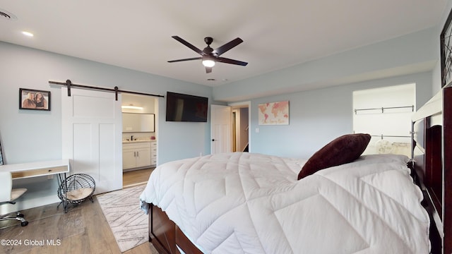 74 Dick Hyatt Ln, Whitehall, NY 12887 - bedroom with wood finished floors, a barn door, ensuite bath, a sink, and recessed lighting