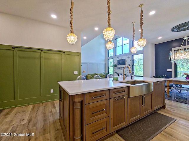 22 Burnham Rd, Wilton, NY 12831 - kitchen with a sink, a decorative wall, a chandelier, light wood-style flooring, and light countertops