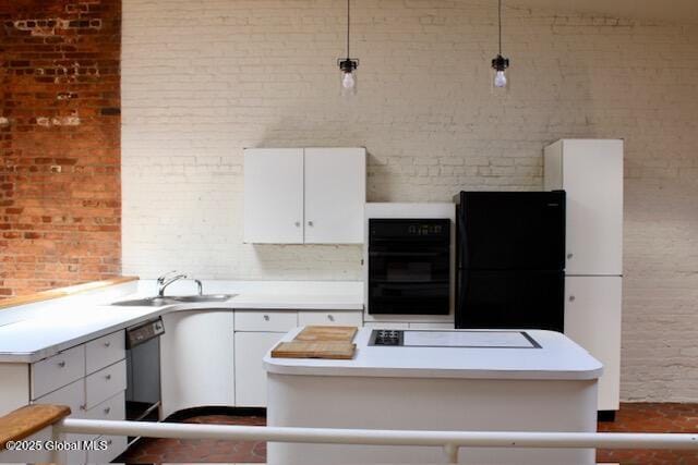 7 Garden Aly, Albany, NY 12210 - kitchen featuring black fridge, cooktop, brick wall, white cabinetry, and a sink