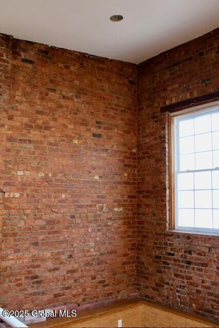 7 Garden Aly, Albany, NY 12210 - empty room with wood finished floors and brick wall