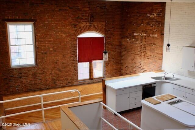 7 Garden Aly, Albany, NY 12210 - kitchen with a sink, black dishwasher, brick wall, and light countertops