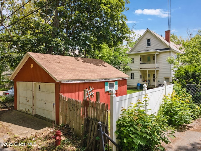 1165 Glenwood Blvd, Schenectady, NY 12308 - rear view of house featuring a garage, an outdoor structure, a shingled roof, and a chimney
