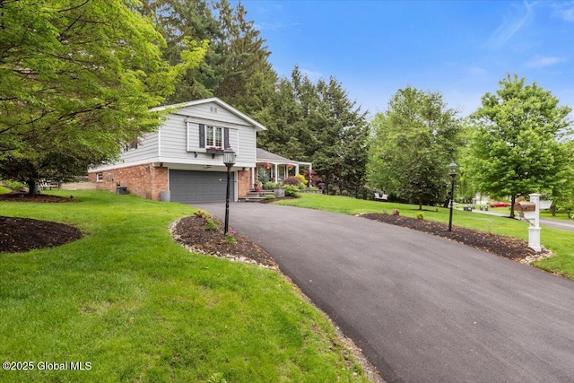 1335 Stanley Ln, Niskayuna, NY 12309 - view of front of home featuring brick siding, asphalt driveway, an attached garage, and a front yard