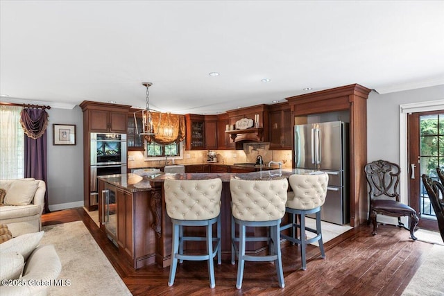 1335 Stanley Ln, Niskayuna, NY 12309 - kitchen with stainless steel appliances, decorative backsplash, crown molding, hanging light fixtures, and dark wood finished floors