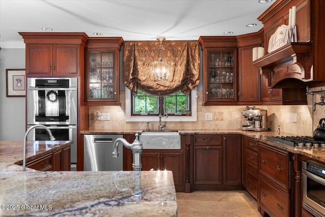 1335 Stanley Ln, Niskayuna, NY 12309 - kitchen featuring appliances with stainless steel finishes, a sink, tasteful backsplash, light stone counters, and a chandelier