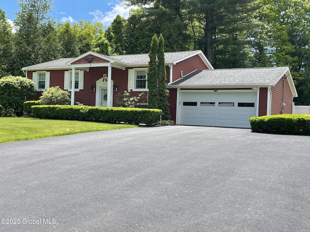 17 Sylvan Ln, Clifton Park, NY 12065 - view of front facade with an attached garage, driveway, a front lawn, and view of wooded area