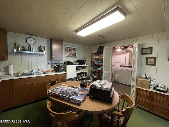 17 Sylvan Ln, Clifton Park, NY 12065 - kitchen featuring washing machine and clothes dryer, a sink, light countertops, open shelves, and brown cabinets