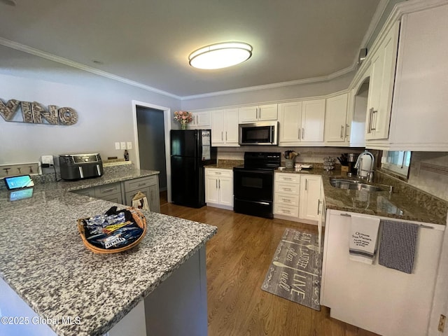 17 Sylvan Ln, Clifton Park, NY 12065 - kitchen with black appliances, a sink, a peninsula, dark stone counters, and ornamental molding