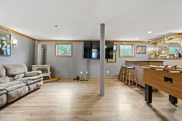 13 Willow Ln, Halfmoon, NY 12118 - recreation room featuring a wood stove, wood finished floors, healthy amount of natural light, crown molding, and recessed lighting