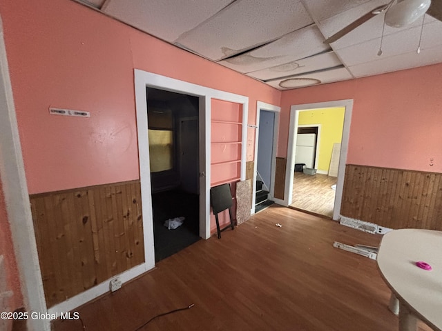 207 Fon Clair St, Johnstown, NY 12095 - spare room with wainscoting, a paneled ceiling, wooden walls, wood finished floors, and stairway