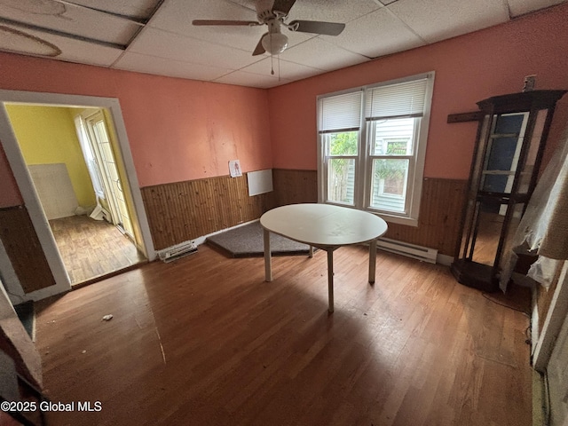 207 Fon Clair St, Johnstown, NY 12095 - dining area featuring wainscoting, a drop ceiling, wood finished floors, a baseboard radiator, and a ceiling fan