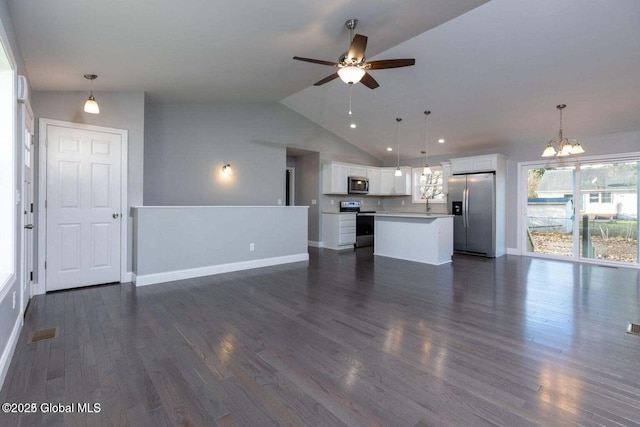 30 W St, Hudson Falls, NY 12839 - unfurnished living room featuring a chandelier, a ceiling fan, vaulted ceiling, baseboards, and dark wood-type flooring