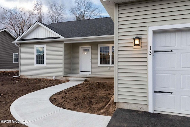 30 W St, Hudson Falls, NY 12839 - view of exterior entry with a garage and a shingled roof