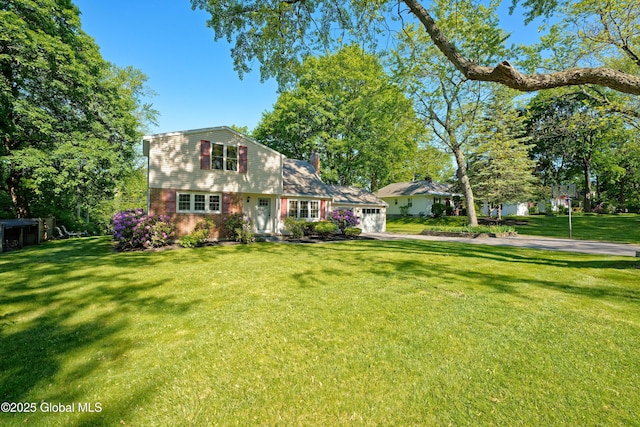 9 S Maple Ln, Colonie, NY 12211 - view of front facade with a garage, a front yard, driveway, brick siding, and a chimney
