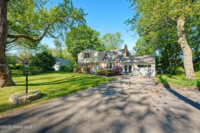 9 S Maple Ln, Colonie, NY 12211 - colonial house with french doors, asphalt driveway, a chimney, a front yard, and an attached garage