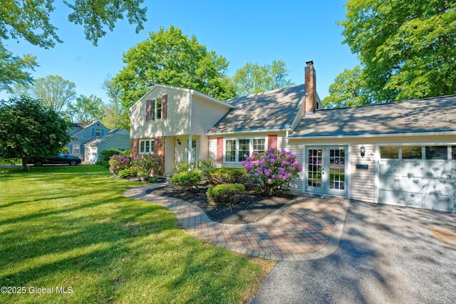 9 S Maple Ln, Colonie, NY 12211 - colonial-style house featuring an attached garage, a front yard, a chimney, french doors, and driveway