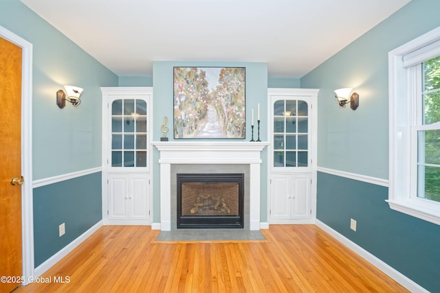 9 S Maple Ln, Colonie, NY 12211 - unfurnished living room featuring wood finished floors, a fireplace with flush hearth, and baseboards