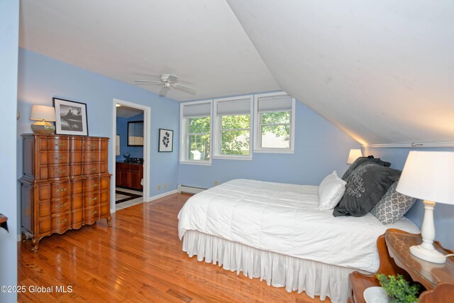 9 S Maple Ln, Colonie, NY 12211 - bedroom with wood finished floors, baseboard heating, lofted ceiling, connected bathroom, and baseboards
