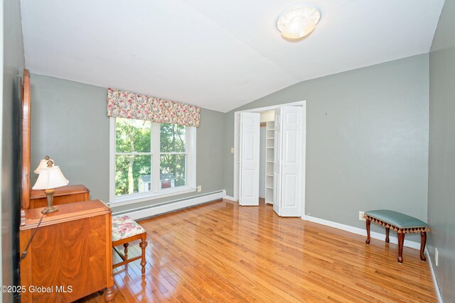9 S Maple Ln, Colonie, NY 12211 - living area featuring a baseboard radiator, lofted ceiling, light wood-type flooring, and baseboards