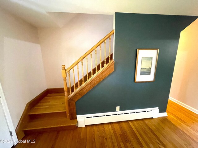 9 S Maple Ln, Colonie, NY 12211 - stairs featuring a baseboard heating unit, baseboards, and wood finished floors