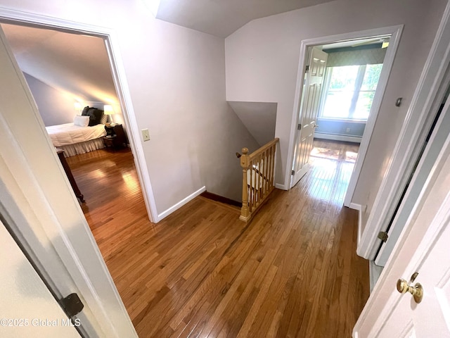 9 S Maple Ln, Colonie, NY 12211 - corridor with an upstairs landing, baseboard heating, wood finished floors, vaulted ceiling, and baseboards