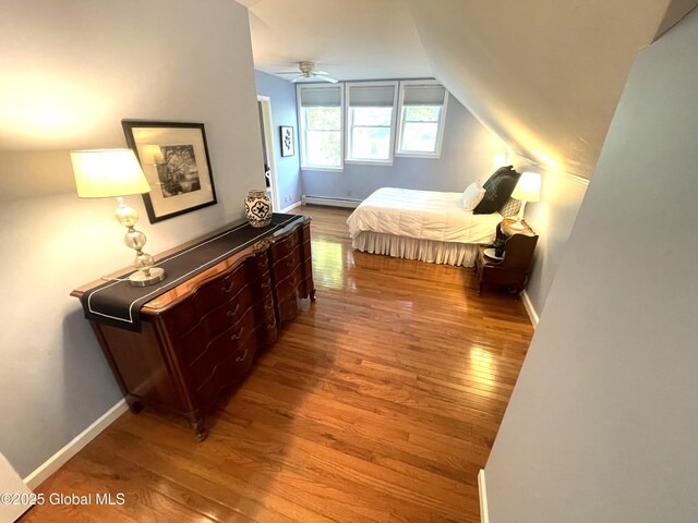 9 S Maple Ln, Colonie, NY 12211 - bedroom featuring wood finished floors, a baseboard radiator, lofted ceiling, and baseboards