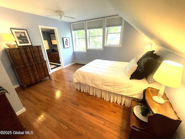 9 S Maple Ln, Colonie, NY 12211 - bedroom featuring hardwood / wood-style flooring, baseboards, ensuite bathroom, vaulted ceiling, and baseboard heating