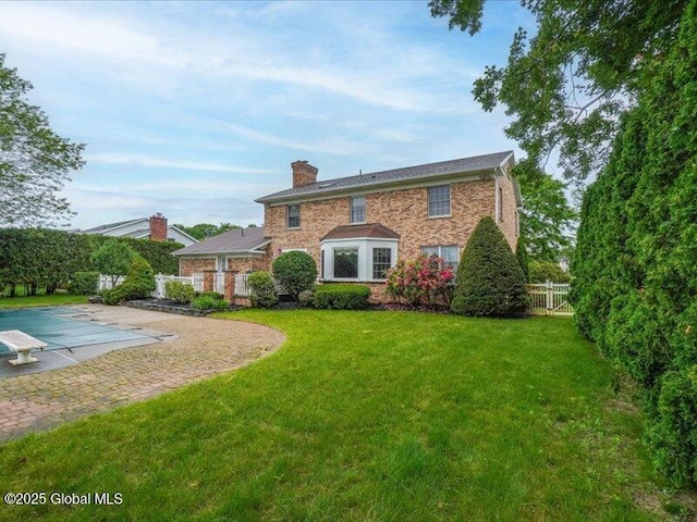 3077 New Williamsburg Dr, Guilderland, NY 12303 - back of property with a chimney, brick siding, and a patio