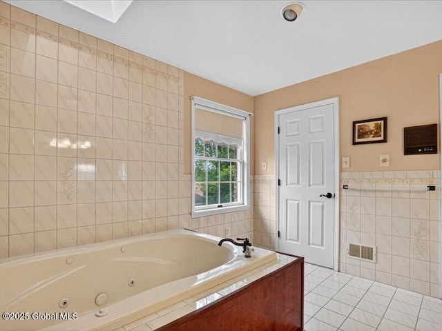 3077 New Williamsburg Dr, Guilderland, NY 12303 - bathroom featuring tile walls, a jetted tub, tile patterned floors, and wainscoting
