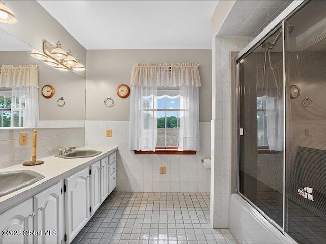 3077 New Williamsburg Dr, Guilderland, NY 12303 - full bath featuring tile walls, tile patterned flooring, double vanity, healthy amount of natural light, and a wainscoted wall