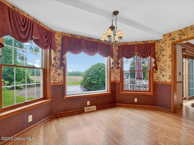 3077 New Williamsburg Dr, Guilderland, NY 12303 - unfurnished dining area featuring wallpapered walls, wood finished floors, a chandelier, healthy amount of natural light, and wainscoting